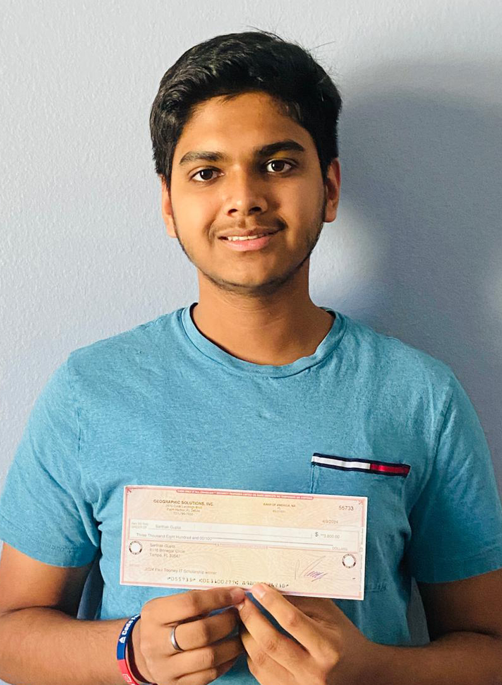 Sarthak Gupta holding IT Scholarship Award check
